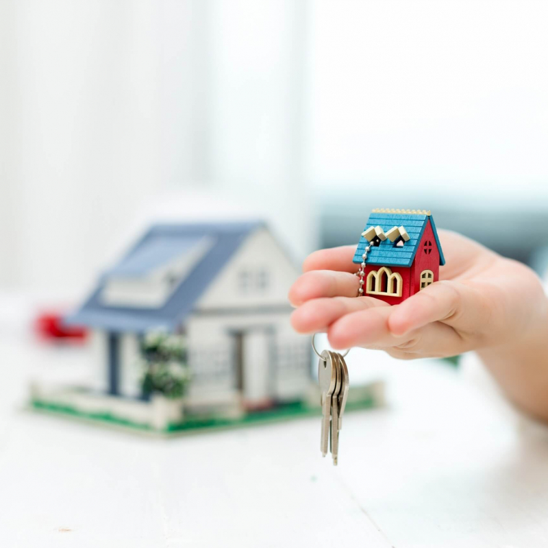 real-estate-agent-with-house-model-keys-scaled
